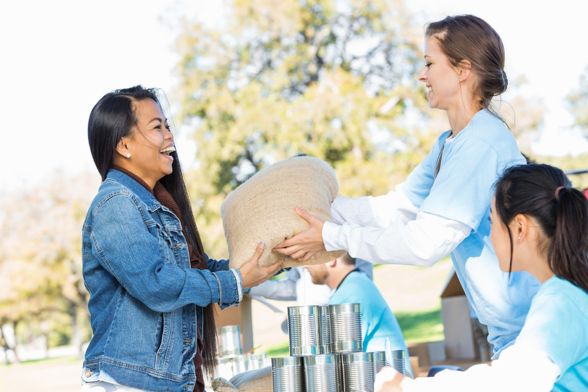Asian woman donating food at outdoor charity event